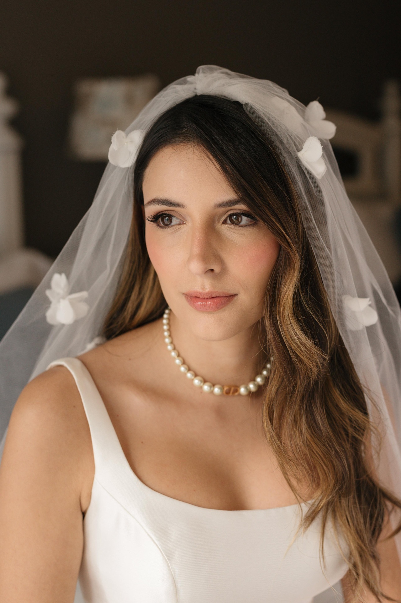Noiva com véu de flores e colar de pérolas